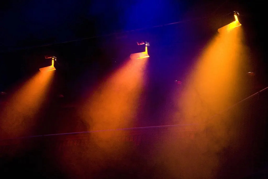 Stage lighting beams in orange and blue