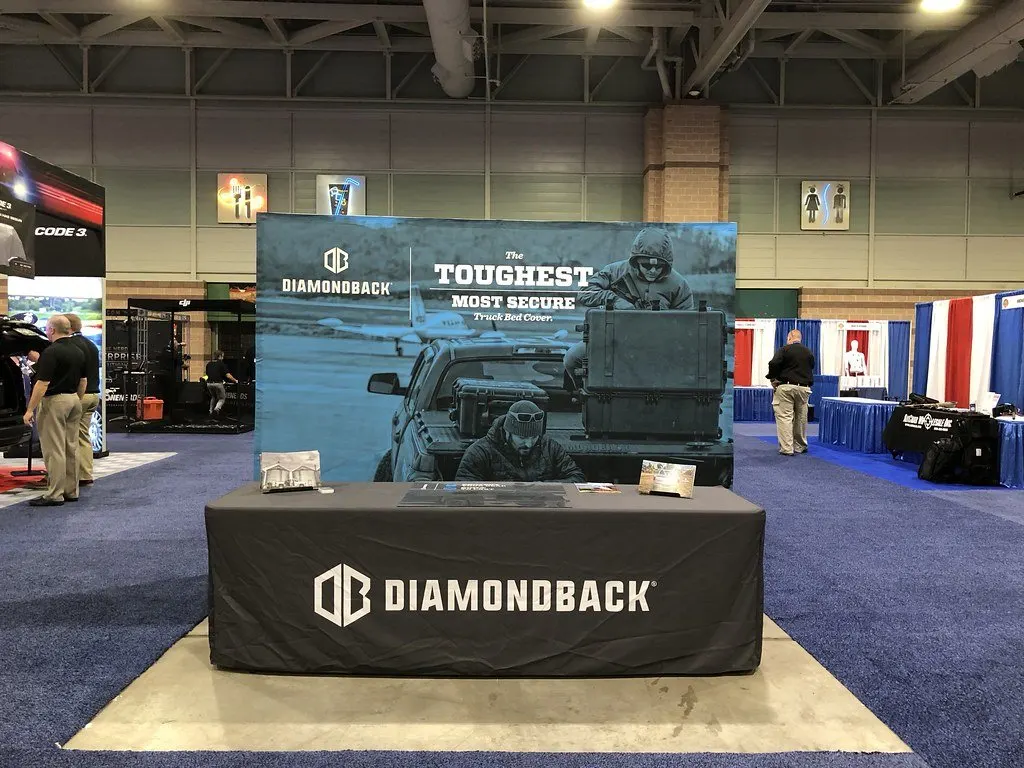 Exhibition booth with a branded counter inside a large exhibition hall