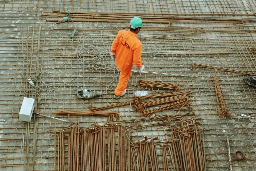 Site worker laying out steel materials during construction