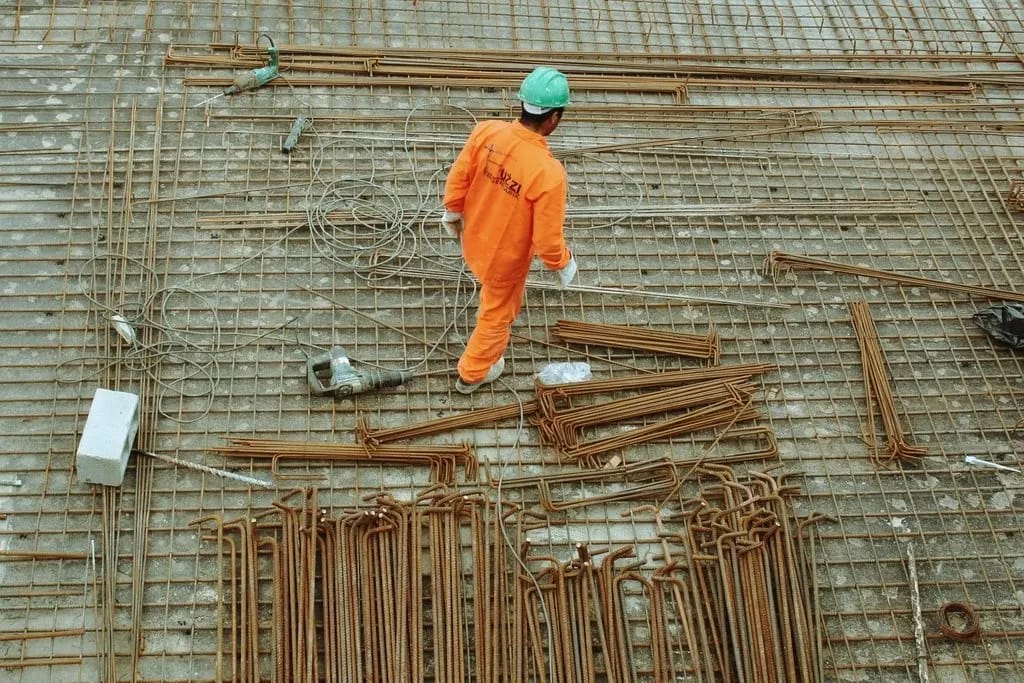 Site worker laying out steel materials during construction